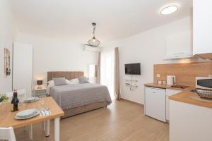 ein Schlafzimmer mit einem Bett und eine Küche mit einem Tisch in der Unterkunft Apartments Lovrić in Vodice