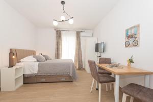 Schlafzimmer mit einem Bett, einem Schreibtisch und einem Tisch in der Unterkunft Apartments Lovrić in Vodice