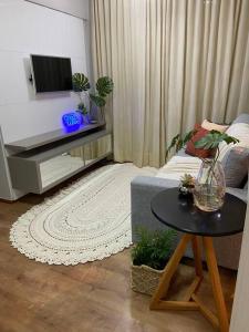 uma sala de estar com um sofá e uma mesa em Apartamento em localização privilegiada em Cuiabá