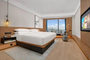 een slaapkamer met een groot bed en een flatscreen-tv bij Fairfield by Marriott Changsha Yuelu in Changsha