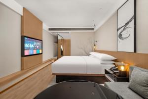 een hotelkamer met een bed en een televisie bij Fairfield by Marriott Changsha Yuelu in Changsha