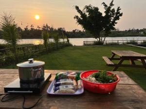 stół z garnkiem i talerzem jedzenia w obiekcie Bình An lake view w mieście Buôn Ma Thuột