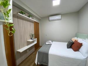 um pequeno quarto com uma cama e algumas plantas em Apartamento em localização privilegiada em Cuiabá