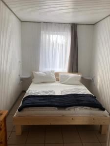 a bed in a small room with a window at Gast-& Logierhaus Am Rheinsberger See in Rheinsberg