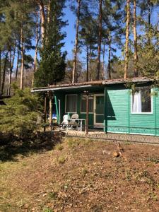 a green house with a table and chairs in front of it at Gast-& Logierhaus Am Rheinsberger See in Rheinsberg