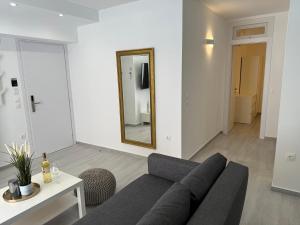 - un salon avec un canapé et un miroir dans l'établissement Central Suites Aegina 4, à Égine