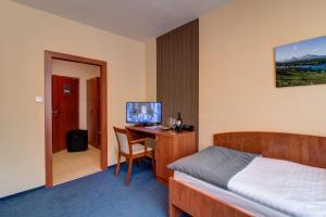 una camera con letto e scrivania con TV di LC - Hotel Ostrava a Ostrava