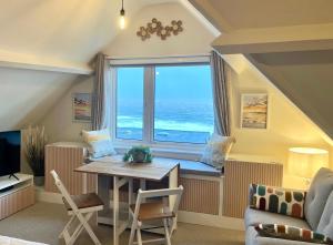 uma sala de estar com uma mesa e uma grande janela em Pier View Retreat - Close to Beach - Sea Views With Parking em Bournemouth