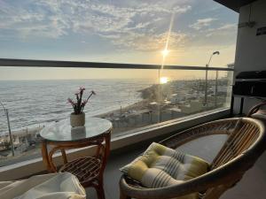 a balcony with a table and chairs and a view of the ocean at Apartamento Playa Señoritas in Punta Hermosa