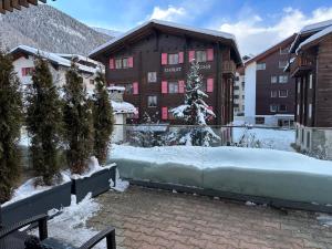 stos śniegu przed budynkiem w obiekcie Hotel Bristol w mieście Zermatt