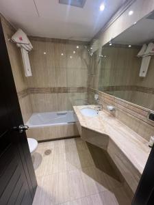 La salle de bains est pourvue d'un lavabo, d'une baignoire et de toilettes. dans l'établissement Ny Suites, à Beyrouth