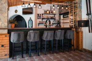 a bar with four stools at a counter in a room at Hotel Sonnenalm Stuhleck in Spital am Semmering