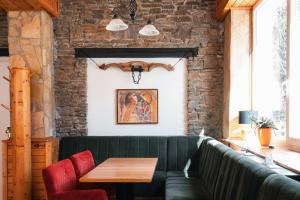 a dining room with a green couch and a wooden table at Hotel Sonnenalm Stuhleck in Spital am Semmering