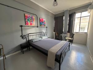 1 dormitorio con cama, mesa y ventanas en Urban Rooms, en Atenas