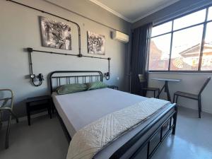 1 dormitorio con cama y ventana grande en Urban Rooms, en Atenas