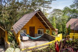 una casa amarilla con una hamaca delante en Refugio Cariguana, en El Valle de Antón