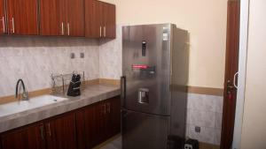 uma cozinha com um frigorífico de aço inoxidável e um lavatório em Kadoued Furnished Apartment 2 Bedroom em Ouagadougou