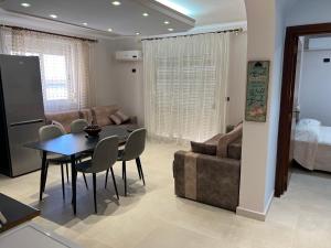 uma sala de estar com uma mesa e um sofá em SKetch Apartments 2 em Durrës