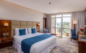 Rúm í herbergi á Golden Tulip Canaan Kampala