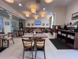 a restaurant with wooden tables and chairs and a tv at Memel Hotel in Klaipėda