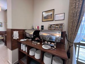 a restaurant with a coffee machine on a shelf at Memel Hotel in Klaipėda