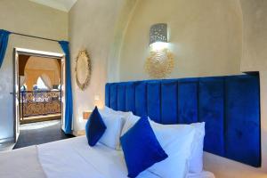 a bed with a blue headboard in a bedroom at Atlas Widan in Marrakech