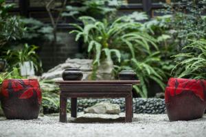 un tavolino in un giardino con due vasi di Buddha Zen Hotel a Chengdu