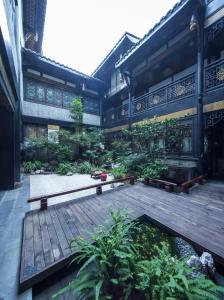 un cortile di un edificio con terrazza in legno di Buddha Zen Hotel a Chengdu