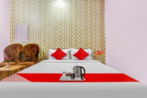 a hotel room with a bed with red pillows at Hotel O K D Guest House in Manesar