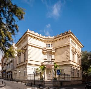 un grand bâtiment blanc au coin d'une rue dans l'établissement Hotel Medium Romantic, à Sitges