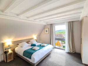 una camera con un letto e una grande finestra di Best Western Hotel & SPA Le Schoenenbourg - Riquewihr - Proche Colmar a Riquewihr