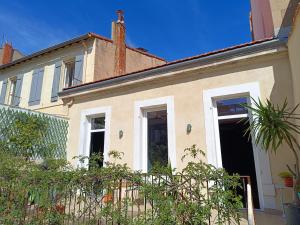 Chambre d'hôtes 2 pers - Maison avec jardin et terrasse près de la Friche de la Belle de mai في مارسيليا: بيت ابيض امامه سياج