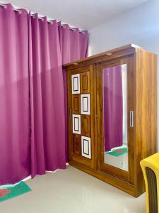 um quarto com cortinas roxas e um espelho em 2 BHK AC Apartment em Pune