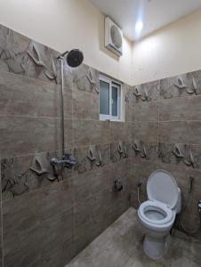 a bathroom with a toilet and a shower at Palm View Residences in Gujrānwāla