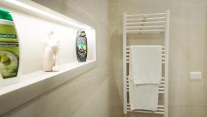 a bathroom with a towel rack and a shelf with towels at Cosmo Beach Apartment in Durrës