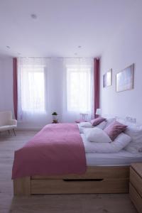 una camera da letto con un grande letto con una coperta rosa di Wagner Villa 902 with free private parking a Budapest