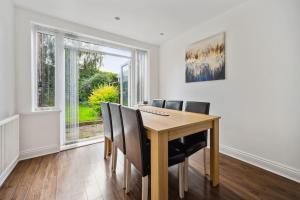 uma sala de jantar com uma mesa de madeira e cadeiras em house in Heald Green village em Manchester