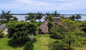 uma imagem de uma casa com vista para a água em Oslo Gardens Bed & Breakfast em Entebbe