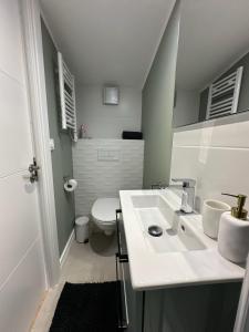 uma casa de banho com um lavatório branco e um WC. em PHEBUS em Berck-sur-Mer