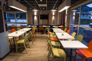 un comedor con mesas, sillas y ventanas en Ibis Budget Sallanches, en Sallanches