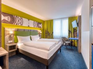 Ένα ή περισσότερα κρεβάτια σε δωμάτιο στο ibis Styles Tuebingen