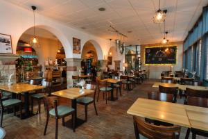 a restaurant with wooden tables and chairs and a bar at Trail-Inn Natur & Sporthotel in Berdorf