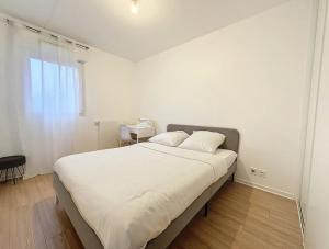 - une chambre avec un grand lit blanc et une table dans l'établissement Le Martray - Spacieux - 4 chambres, à Rennes