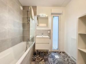 La salle de bains blanche est pourvue d'un lavabo et d'une baignoire. dans l'établissement Le Martray - Spacieux - 4 chambres, à Rennes