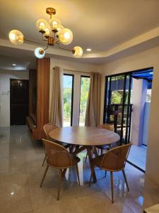 a dining room with a wooden table and chairs at Riverduplex - Luxury duplex at a fair price in Dauis