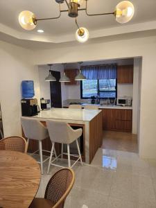 a kitchen with a table and chairs and a counter at Riverduplex - Luxury duplex at a fair price in Dauis