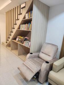 a living room with a chair and a book shelf at Riverduplex - Luxury duplex at a fair price in Dauis