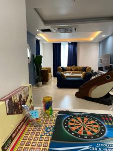 uma sala de estar com um sofá e uma mesa com um alvo de dardos em Gold Crest Executive Signature Luxury Apartments DHA Phase 4 Lahore by LMY em Lahore