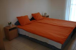 een slaapkamer met een bed met een oranje dekbed bij Szegedi Partfürdő Kemping és Apartman in Szeged