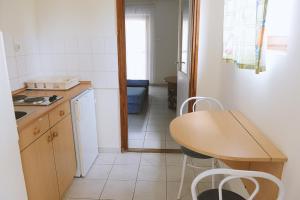 een keuken met een tafel en een tafel en stoelen bij Szegedi Partfürdő Kemping és Apartman in Szeged